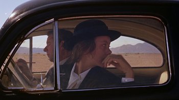 Movie still from “Walkabout” (1971), directed by Nicolas Roeg – A man and a woman sitting in the back seat of a car; Medium shot, Over the shoulder angle