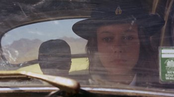 Movie still from “Walkabout” (1971), directed by Nicolas Roeg – A woman in a police uniform looking out of a car window; Close Up shot, Over the shoulder angle