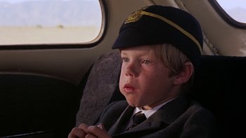 Movie still from “Walkabout” (1971), directed by Nicolas Roeg – A boy in a uniform sitting in the back of an airplane; Close Up shot, Low angle