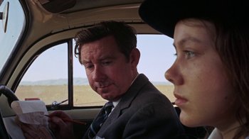Movie still from “Walkabout” (1971), directed by Nicolas Roeg – A man and a woman sitting in the back of a car; Close Up shot, Over the shoulder angle