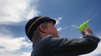 Movie still from “Walkabout” (1971), directed by Nicolas Roeg – A young boy in a hat is holding a frisbee; Close Up shot, Low angle