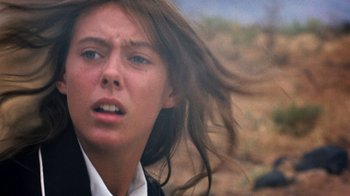 Movie still from “Walkabout” (1971), directed by Nicolas Roeg – A woman with long brown hair is looking at the camera; Close Up shot, Low angle