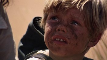 Movie still from “Walkabout” (1971), directed by Nicolas Roeg – A child with dirt all over his face; Close Up shot, Low angle