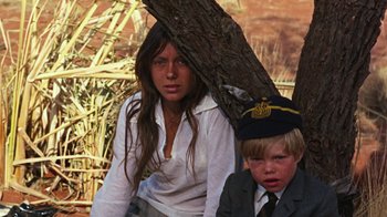 Movie still from “Walkabout” (1971), directed by Nicolas Roeg – A woman and a young boy standing next to each other; Medium shot, High angle
