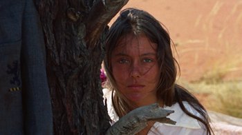 Movie still from “Walkabout” (1971), directed by Nicolas Roeg – A young girl is standing next to a tree; Close Up shot, Low angle