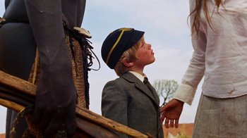 Movie still from “Walkabout” (1971), directed by Nicolas Roeg – A young boy wearing a hat looking up at something; Medium shot, Low angle