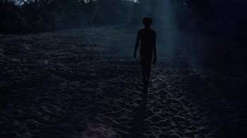 Movie still from “Walkabout” (1971), directed by Nicolas Roeg – A person walking on a beach in the dark; Extreme Wide shot, Low angle