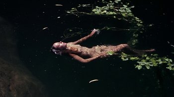 Movie still from “Walkabout” (1971), directed by Nicolas Roeg – A woman floating in the water in a body of water; Wide shot, Overhead angle