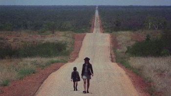 Movie still from “Walkabout” (1971), directed by Nicolas Roeg – A woman and a child walking down a dirt road; Wide shot, High angle