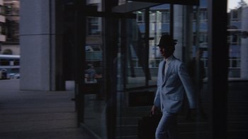 Movie still from “Walkabout” (1971), directed by Nicolas Roeg – A man in a suit and hat walking down a street; Wide shot, Low angle
