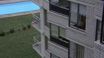 Movie still from “Walkabout” (1971), directed by Nicolas Roeg – An apartment building with a swimming pool in the background; Extreme Wide shot, High angle