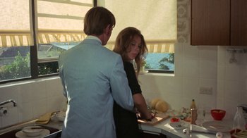 Movie still from “Walkabout” (1971), directed by Nicolas Roeg – A man and a woman standing in a kitchen preparing food; Medium shot, High angle