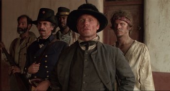 Movie still from “Walker” (1987), directed by Alex Cox – A group of men standing next to each other in a room; Medium shot, Low angle
