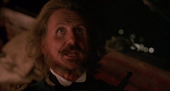 Movie still from “Walker” (1987), directed by Alex Cox – A person with long hair and a beard; Close Up shot, Low angle