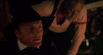 Movie still from “Walker” (1987), directed by Alex Cox – A man and a woman in a dark room; Close Up shot, Over the shoulder angle