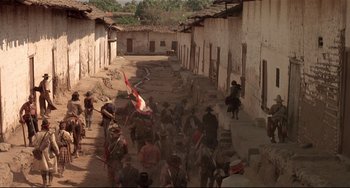 Movie still from “Walker” (1987), directed by Alex Cox – A group of people walking down a dirt road; Extreme Wide shot, High angle