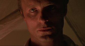 Movie still from “Walker” (1987), directed by Alex Cox – A person's face in the dark; Close Up shot, Low angle