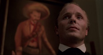 Movie still from “Walker” (1987), directed by Alex Cox – A person wearing a suit and tie; Close Up shot, Low angle