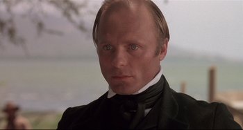 Movie still from “Walker” (1987), directed by Alex Cox – A person wearing a suit and tie; Close Up shot, Low angle