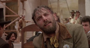 Movie still from “Walker” (1987), directed by Alex Cox – A person wearing a suit and tie; Close Up shot, Low angle