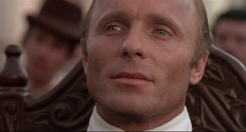 Movie still from “Walker” (1987), directed by Alex Cox – A person wearing a suit and tie; Close Up shot, Low angle