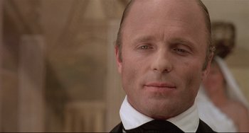 Movie still from “Walker” (1987), directed by Alex Cox – A person wearing a suit and tie; Close Up shot, Low angle