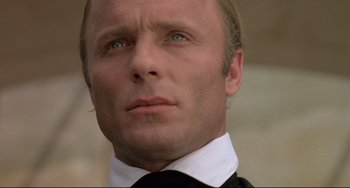 Movie still from “Walker” (1987), directed by Alex Cox – A person wearing a suit and tie; Close Up shot, Low angle