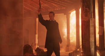 Movie still from “Walker” (1987), directed by Alex Cox – A man holding an umbrella while standing in a room; Medium shot, Low angle