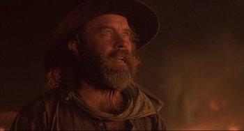 Movie still from “Walker” (1987), directed by Alex Cox – A man with long hair and a beard wearing a hat; Close Up shot, Low angle