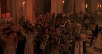 Movie still from “Walker” (1987), directed by Alex Cox – A large group of people standing in front of a building at night; Wide shot, High angle