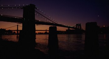 Movie still from “Wall Street” (1987), directed by Oliver Stone – A view of the brooklyn bridge at night; Extreme Wide shot, Low angle