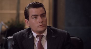 Movie still from “Wall Street” (1987), directed by Oliver Stone – A man in a suit and tie; Close Up shot, High angle