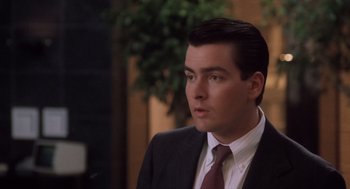 Movie still from “Wall Street” (1987), directed by Oliver Stone – A man in a suit and tie looking to his left; Close Up shot, High angle