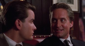 Movie still from “Wall Street” (1987), directed by Oliver Stone – Two men in business suits talking to each other; Close Up shot, Over the shoulder angle