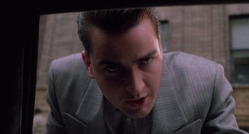 Movie still from “Wall Street” (1987), directed by Oliver Stone – A person wearing a suit and tie; Close Up shot, Low angle