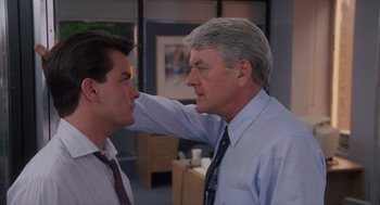 Movie still from “Wall Street” (1987), directed by Oliver Stone – A man and a man in business clothes touching each other's face; Close Up shot, Over the shoulder angle