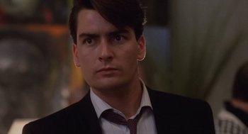 Movie still from “Wall Street” (1987), directed by Oliver Stone – A person wearing a suit and tie; Close Up shot, Low angle
