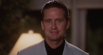 Movie still from “Wall Street” (1987), directed by Oliver Stone – A person wearing a suit and smiling; Close Up shot, Low angle