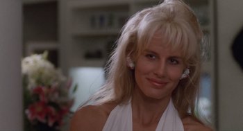 Movie still from “Wall Street” (1987), directed by Oliver Stone – A woman with blonde hair wearing a white top; Close Up shot, Over the shoulder angle