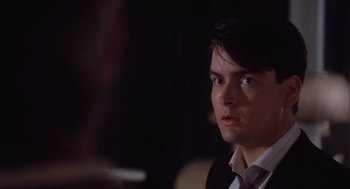 Movie still from “Wall Street” (1987), directed by Oliver Stone – A man in a suit and tie looking to his left; Close Up shot, Over the shoulder angle