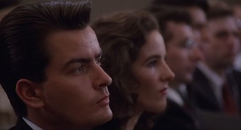 Movie still from “Wall Street” (1987), directed by Oliver Stone – A man and a woman are sitting next to each other; Close Up shot, Low angle