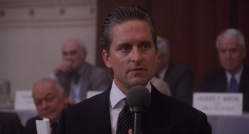 Movie still from “Wall Street” (1987), directed by Oliver Stone – A person speaking into a microphone; Close Up shot, Over the shoulder angle