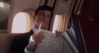 Movie still from “Wall Street” (1987), directed by Oliver Stone – A man in a business suit holding a paper and a pencil; Close Up shot, Low angle
