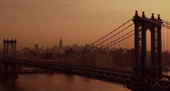 Movie still from “Wall Street” (1987), directed by Oliver Stone – A view of a bridge and a city at sunset; Extreme Wide shot, High angle