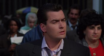 Movie still from “Wall Street” (1987), directed by Oliver Stone – A person wearing a suit and tie; Close Up shot, Over the shoulder angle