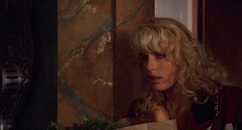 Movie still from “Wall Street” (1987), directed by Oliver Stone – A woman with blonde curly hair looking into a mirror; Close Up shot, Over the shoulder angle