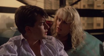 Movie still from “Wall Street” (1987), directed by Oliver Stone – A man and a woman sitting next to each other; Close Up shot, Over the shoulder angle
