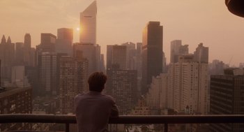 Movie still from “Wall Street” (1987), directed by Oliver Stone – A man sitting on a balcony looking out at a city skyline; Extreme Wide shot, Over the shoulder angle