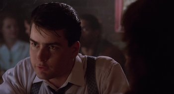 Movie still from “Wall Street” (1987), directed by Oliver Stone – A young man in a white dress shirt and tie; Close Up shot, Over the shoulder angle