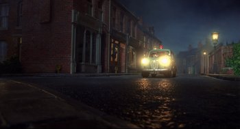 Movie still from “Wallace & Gromit: The Curse of the Were-Rabbit” (2005), directed by Nick Park – A police car driving down a street at night; Extreme Wide shot, Low angle